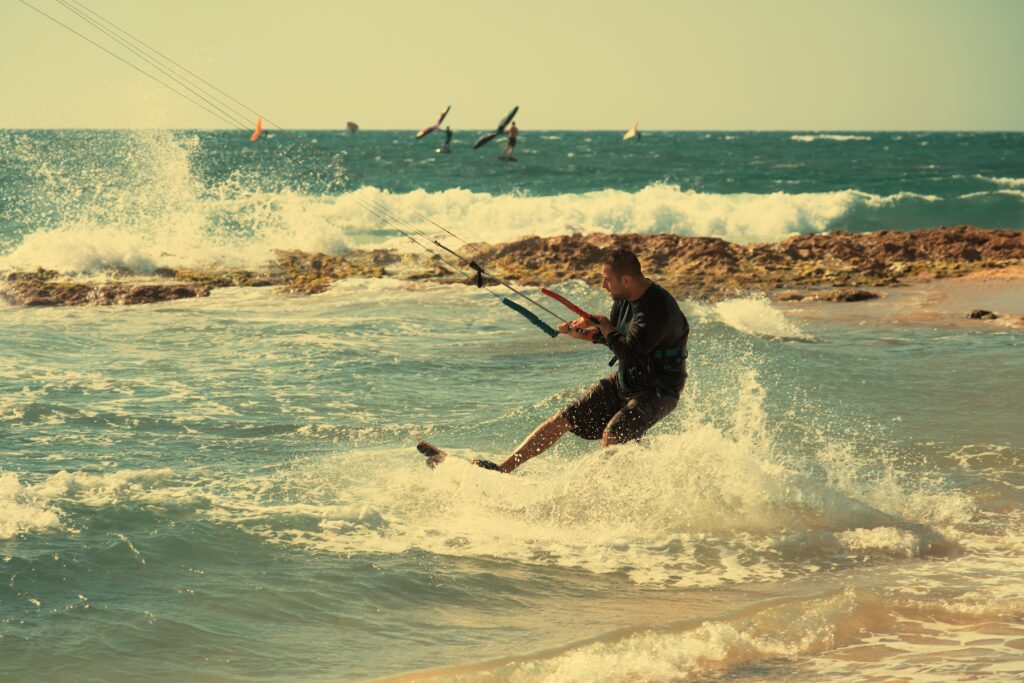 Surfer riding a wave at Gordon Beach in Tel Aviv at sunset.